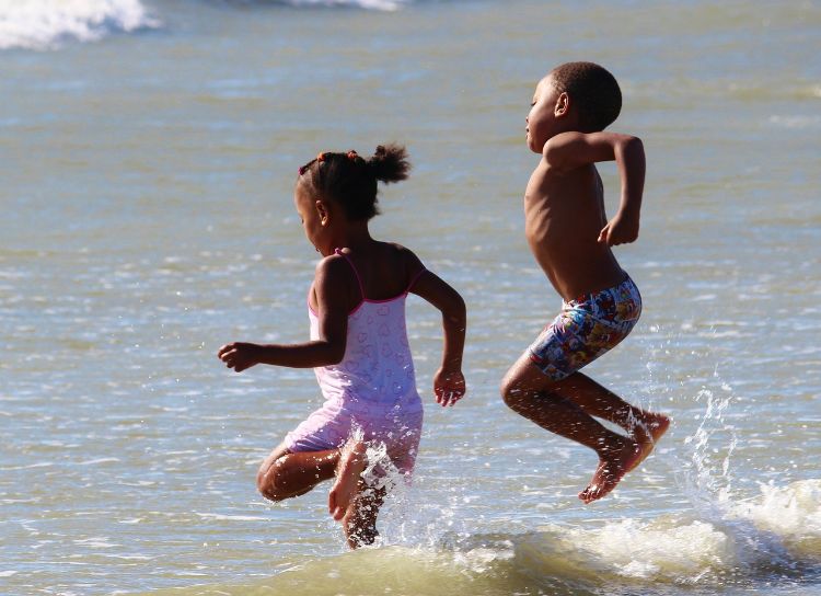 Two children jumping and splashing in the water