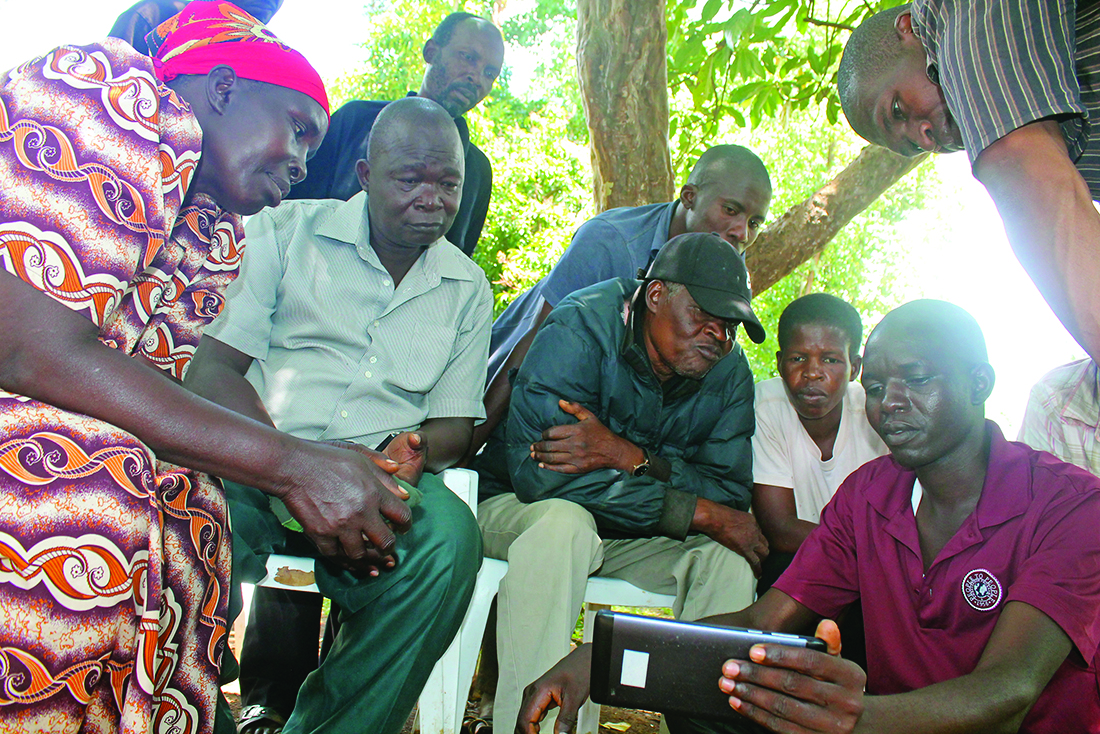 Man showing a group of people a picture on his phone