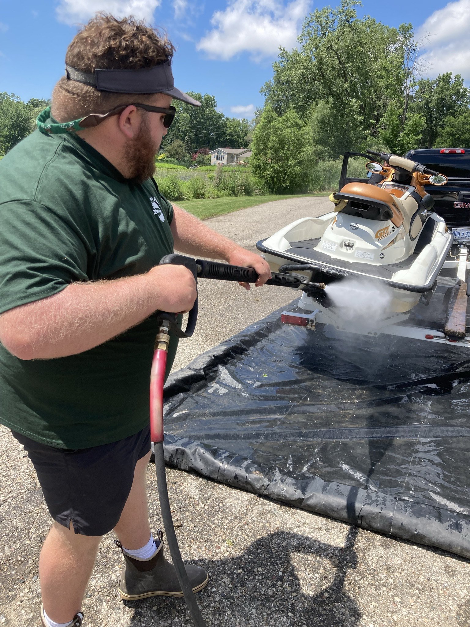 Mobile Boat Wash intern cleaning a boat at a boat washing station.