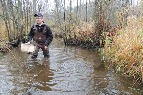 Male student wading in the river. Male student wading in the river.