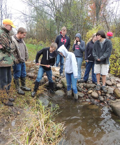 Group of students collecting samples from river. Group of students collecting samples from river.